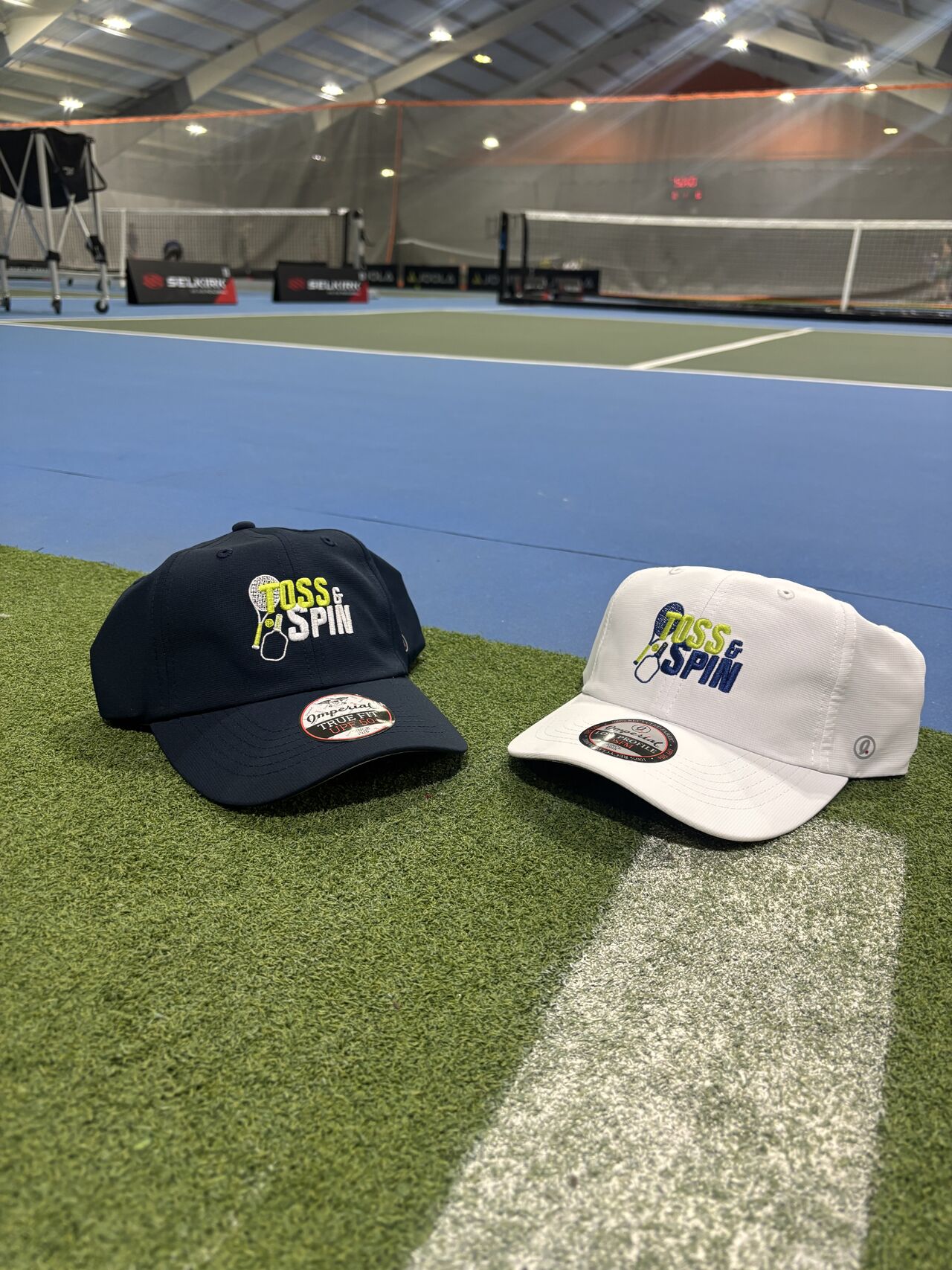 Imperial Toss and Spin performance hat and visor displayed on a green textured surface